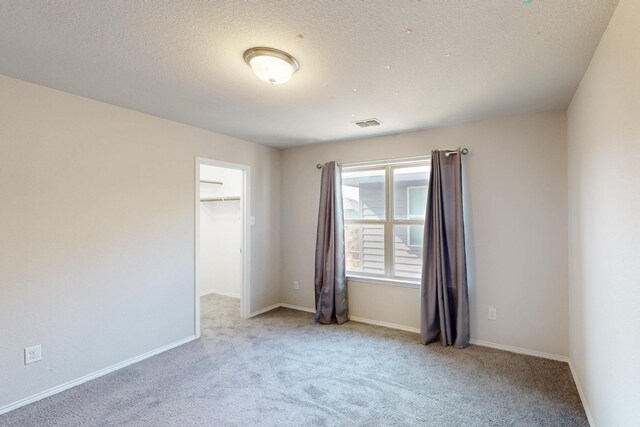 spare room with light carpet and a textured ceiling