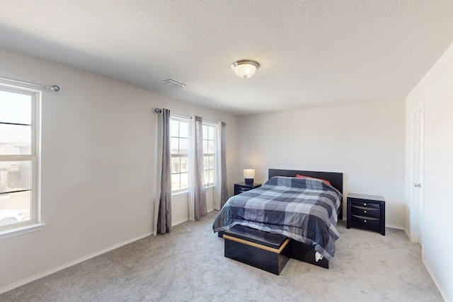 bedroom with light carpet and a textured ceiling