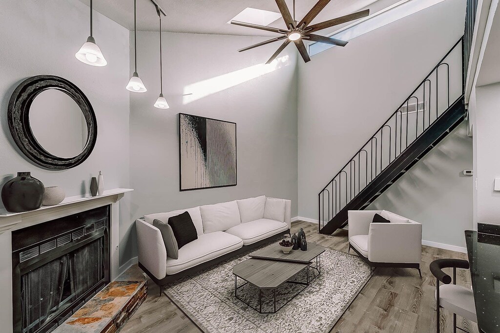 living room with stairs, wood finished floors, baseboards, and ceiling fan