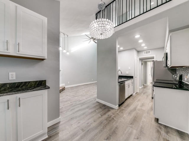 kitchen with white cabinets, decorative light fixtures, and appliances with stainless steel finishes