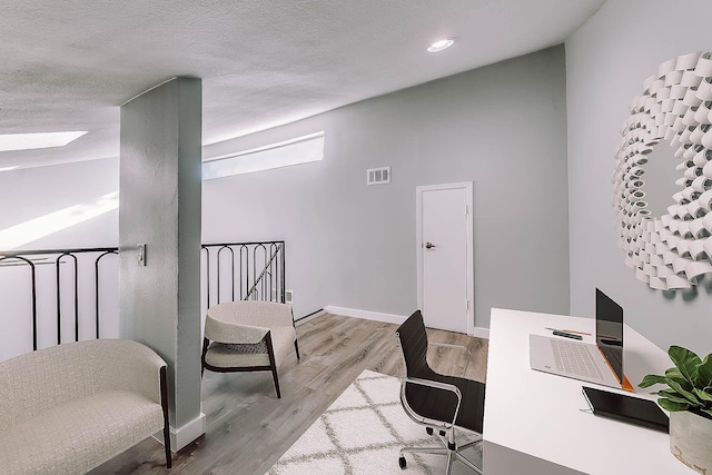 office featuring light hardwood / wood-style floors and a textured ceiling