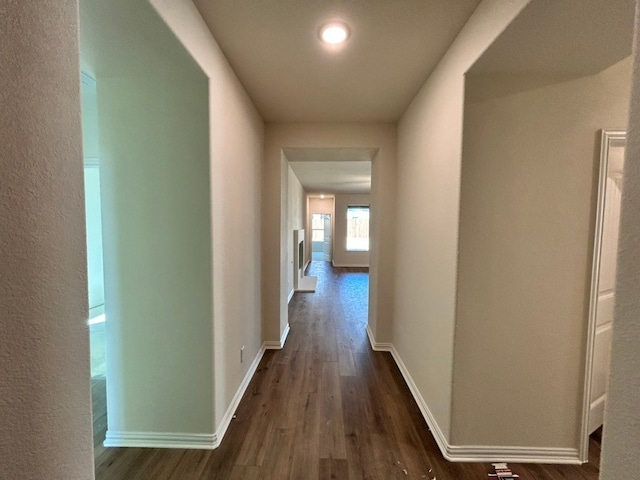 hallway featuring dark wood-style floors and baseboards