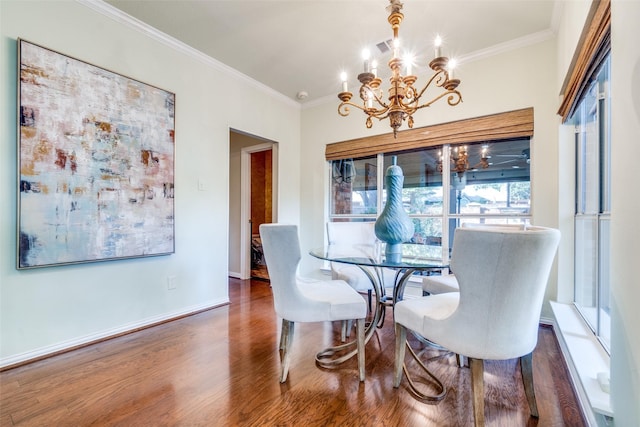 dining area featuring dark hardwood / wood-style flooring, a notable chandelier, and crown molding