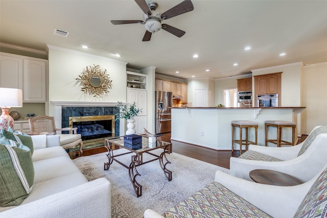 living room with ornamental molding, ceiling fan, a fireplace, and dark hardwood / wood-style flooring