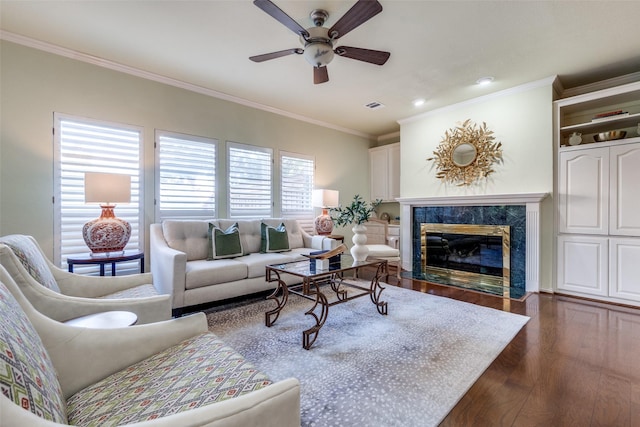 living room featuring crown molding, ceiling fan, a high end fireplace, and dark hardwood / wood-style flooring