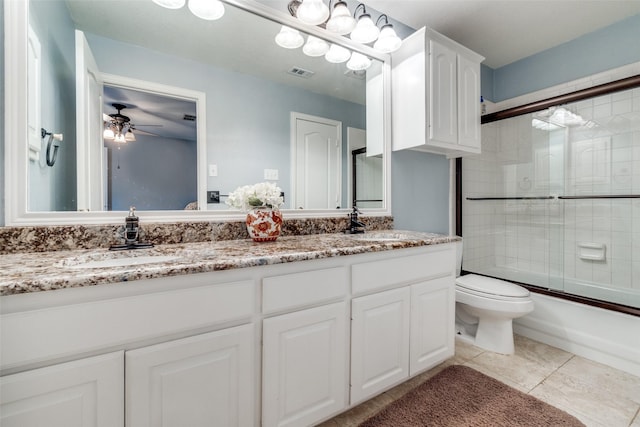 full bathroom featuring enclosed tub / shower combo, vanity, ceiling fan, toilet, and tile patterned floors