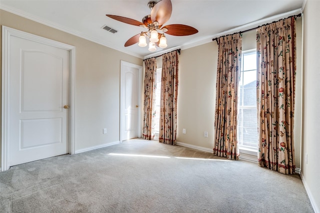 spare room featuring crown molding, ceiling fan, and light carpet