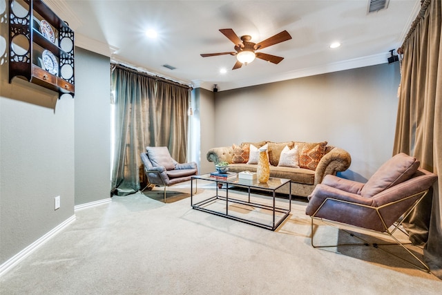 carpeted living room with ornamental molding and ceiling fan