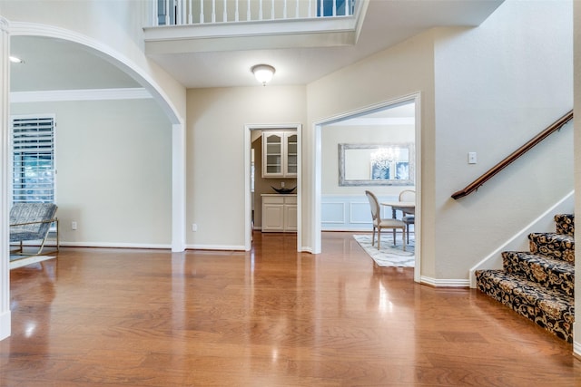 foyer entrance with wood-type flooring and ornamental molding