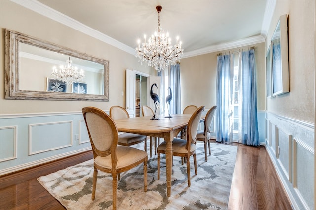 dining room featuring hardwood / wood-style flooring, ornamental molding, and a notable chandelier