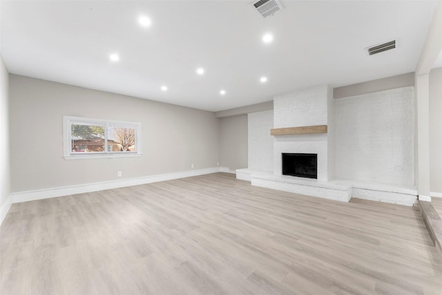 unfurnished living room featuring light wood-type flooring and a fireplace