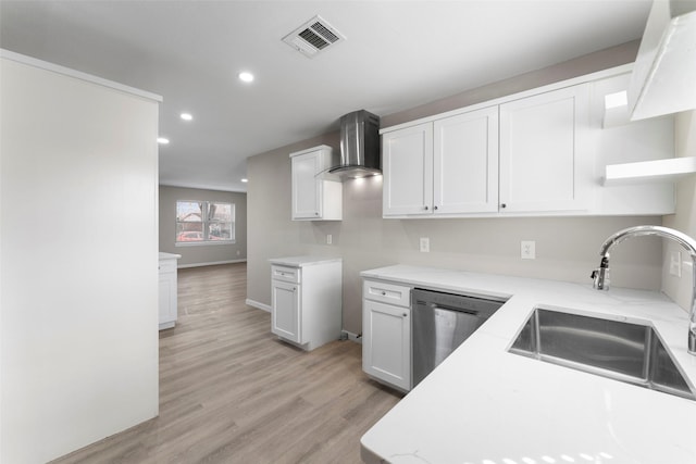 kitchen featuring wall chimney range hood, white cabinetry, sink, light wood-type flooring, and stainless steel dishwasher