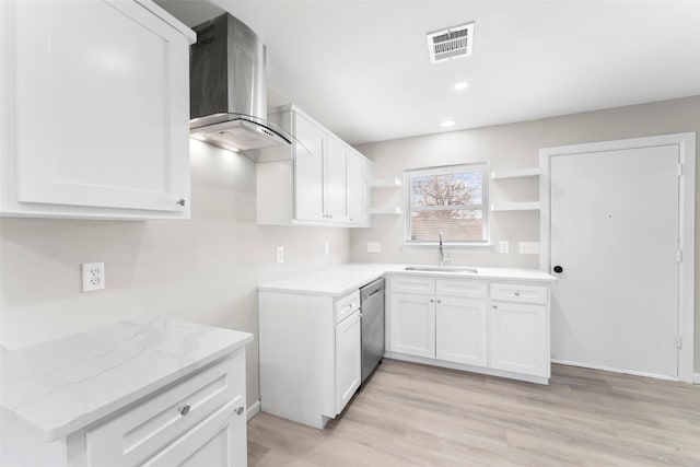 kitchen featuring white cabinetry, dishwasher, wall chimney range hood, light stone counters, and sink