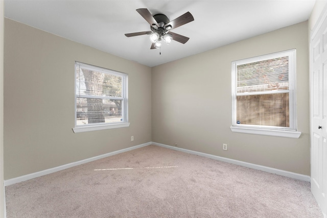 carpeted spare room with ceiling fan