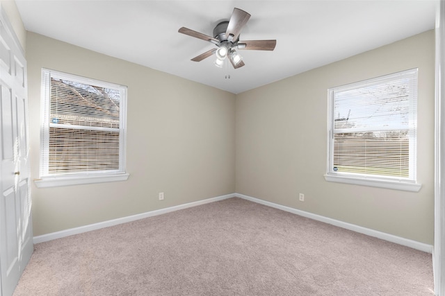 carpeted spare room featuring ceiling fan