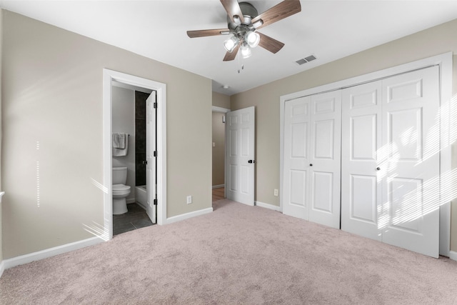 unfurnished bedroom featuring ensuite bath, ceiling fan, a closet, and carpet flooring