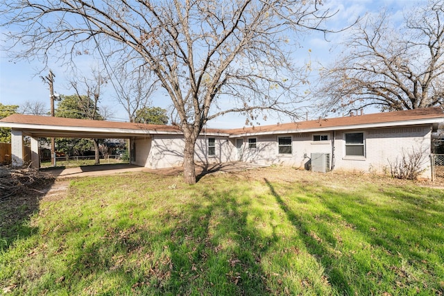 rear view of property with a lawn and a carport