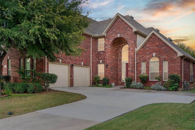 view of front of property with a garage and a lawn