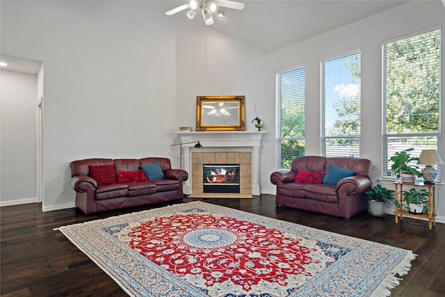 living room with dark hardwood / wood-style flooring, a tile fireplace, and ceiling fan