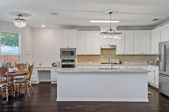 kitchen featuring light stone counters, appliances with stainless steel finishes, hanging light fixtures, and white cabinets