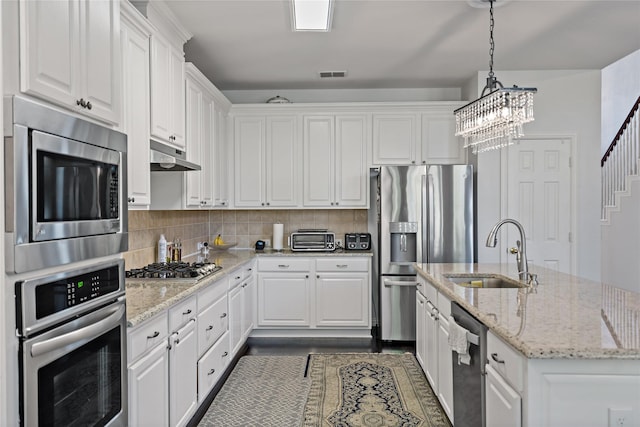 kitchen featuring white cabinetry, stainless steel appliances, sink, and hanging light fixtures