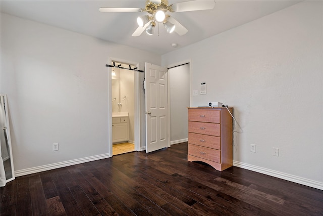 unfurnished bedroom featuring dark wood-type flooring, ceiling fan, and ensuite bath