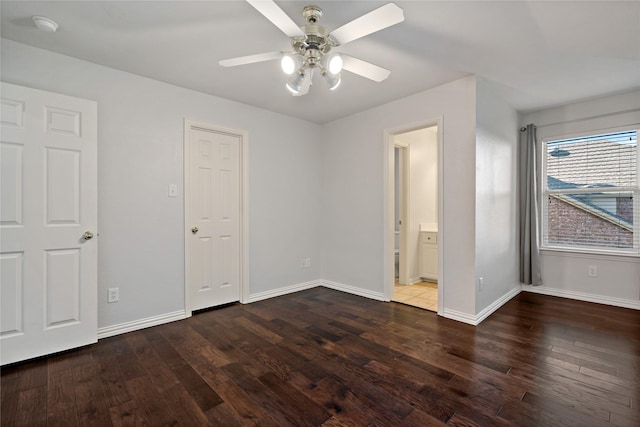 unfurnished bedroom featuring dark hardwood / wood-style flooring, ensuite bath, and ceiling fan