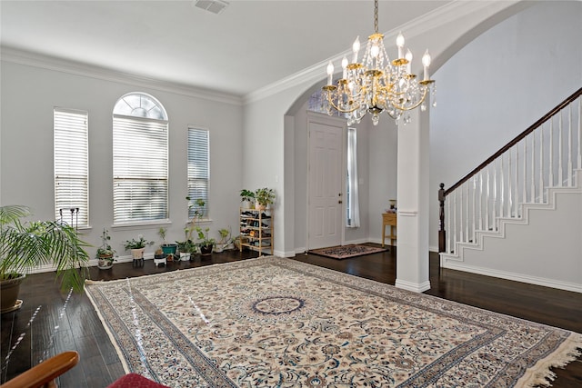 entryway with ornamental molding, dark hardwood / wood-style floors, and an inviting chandelier