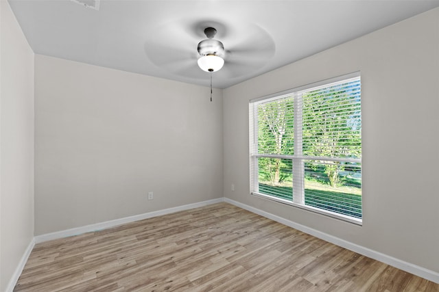 empty room with ceiling fan and light hardwood / wood-style floors