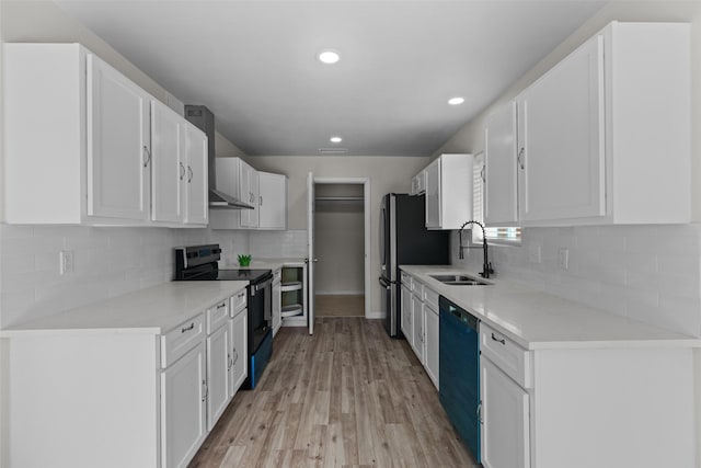 kitchen with appliances with stainless steel finishes, light hardwood / wood-style floors, white cabinetry, and sink