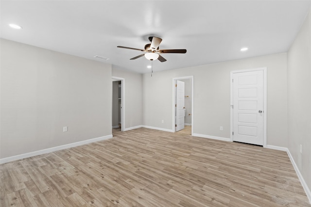 empty room with ceiling fan and light hardwood / wood-style flooring