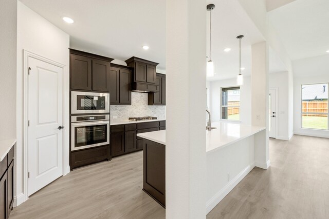 1217 Sylvia St, Desoto, TX 75115 - kitchen featuring appliances with stainless steel finishes, tasteful backsplash, light wood-style flooring, dark brown cabinetry, and recessed lighting