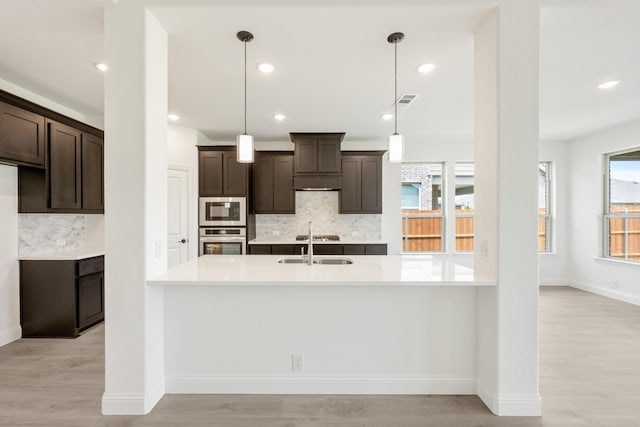 1217 Sylvia St, Desoto, TX 75115 - kitchen featuring stainless steel appliances, dark brown cabinets, light countertops, decorative backsplash, and recessed lighting