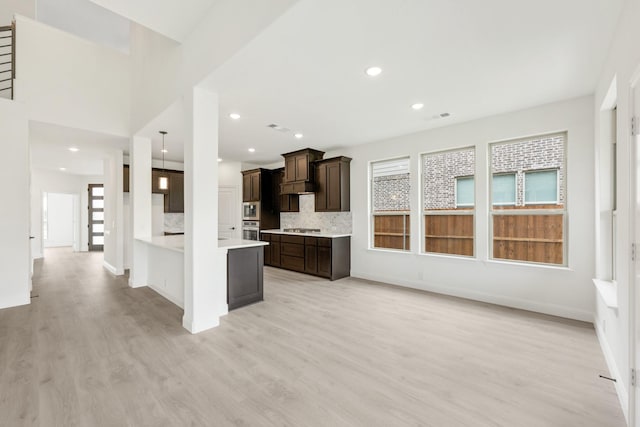1217 Sylvia St, Desoto, TX 75115 - kitchen featuring dark brown cabinetry, light wood-style floors, light countertops, appliances with stainless steel finishes, and recessed lighting
