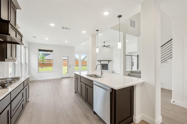 1217 Sylvia St, Desoto, TX 75115 - kitchen featuring stainless steel appliances, a sink, open floor plan, light wood-style floors, and ceiling fan