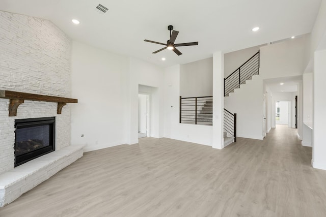 1217 Sylvia St, Desoto, TX 75115 - unfurnished living room with ceiling fan, wood finished floors, stairway, a towering ceiling, and a fireplace