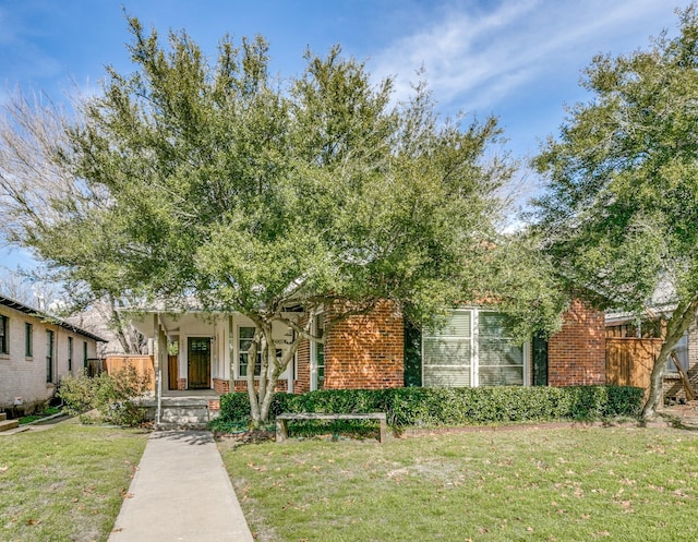 view of property hidden behind natural elements featuring a front yard