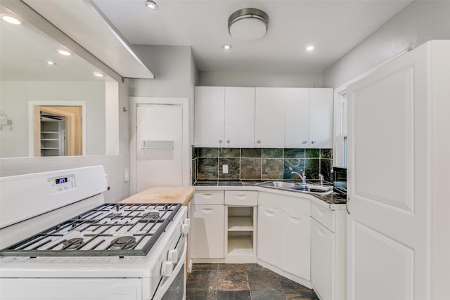 kitchen with decorative backsplash, sink, white cabinetry, and gas range gas stove