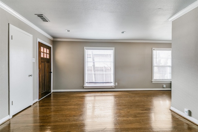 foyer entrance featuring a textured ceiling, ornamental molding, and dark hardwood / wood-style flooring