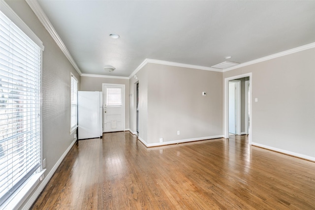 empty room with ornamental molding and wood-type flooring