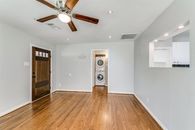 entrance foyer featuring ceiling fan, stacked washer / drying machine, and light hardwood / wood-style flooring