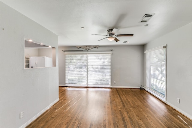 spare room with ceiling fan, dark hardwood / wood-style flooring, and a wealth of natural light