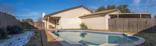 rear view of house with ceiling fan and a fenced in pool