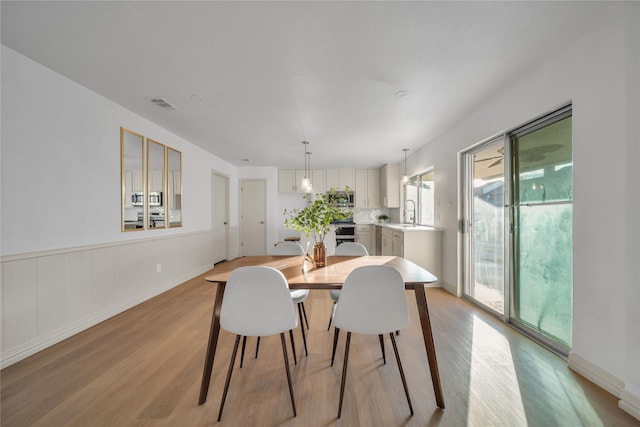 dining space featuring light hardwood / wood-style floors and sink