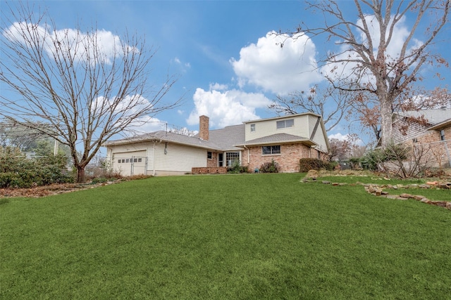 rear view of property featuring a garage and a yard