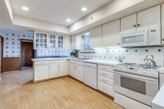 kitchen with sink, white cabinets, white appliances, and light hardwood / wood-style floors