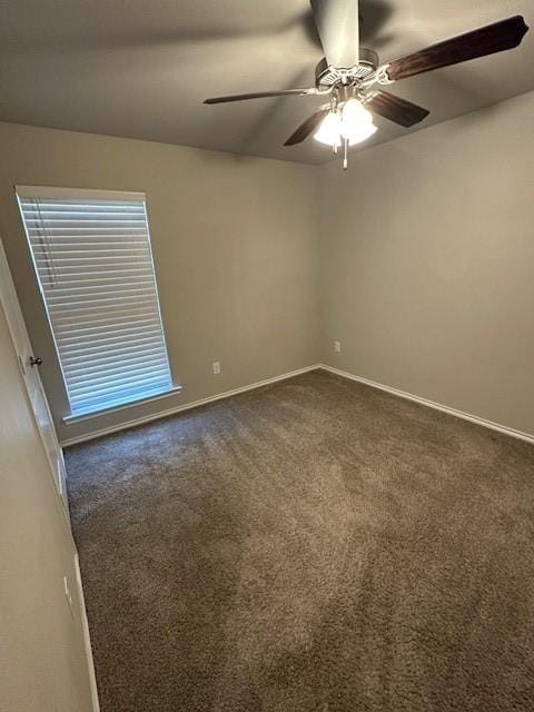 unfurnished room with dark colored carpet and ceiling fan