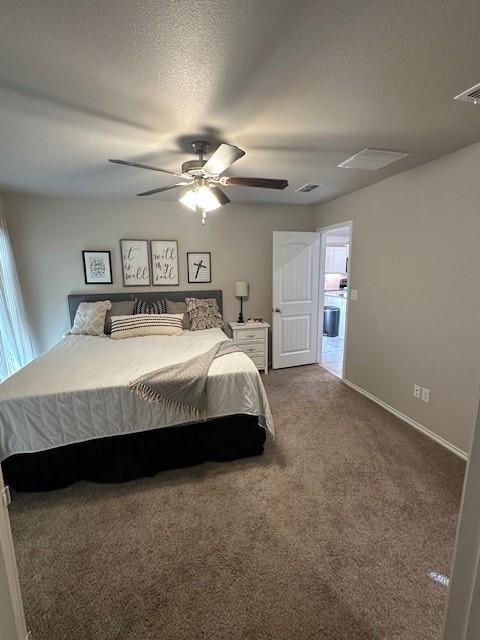 carpeted bedroom featuring ceiling fan and a textured ceiling