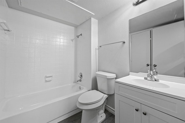 full bathroom with a textured ceiling, wood-type flooring, washtub / shower combination, vanity, and toilet