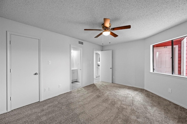 unfurnished bedroom with ceiling fan, carpet, and a textured ceiling